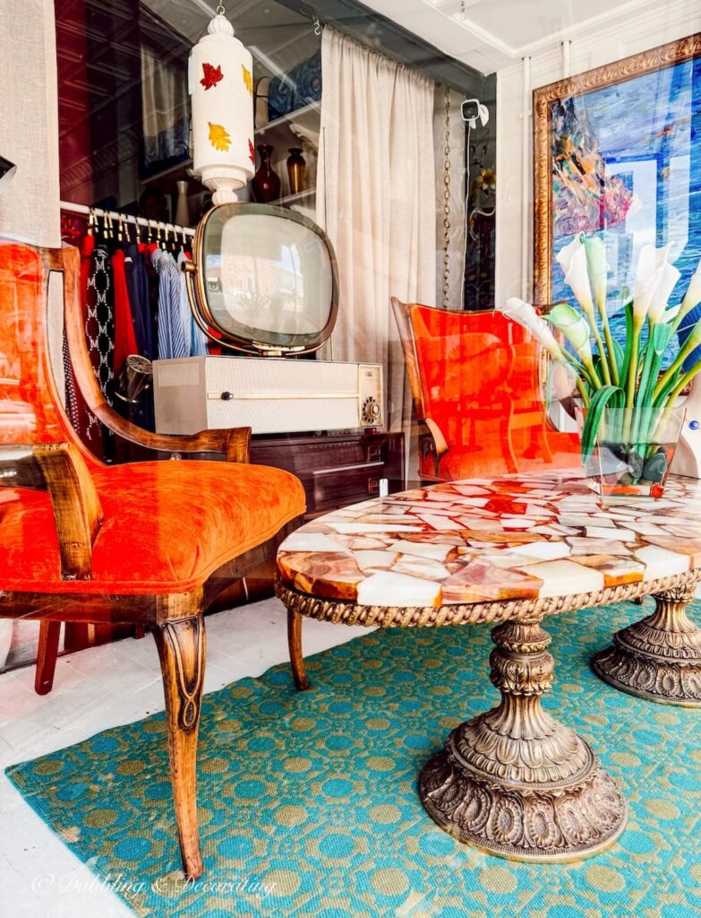Window shopping on Warren Street in Hudson NY, Mid century modern orange chairs with retro flat television designed in window display.
