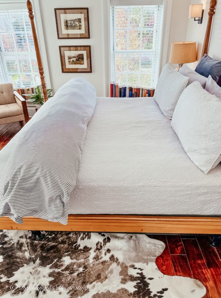 Mercer bedroom with four poster bed, cowhide rug and fireplace at the WM Farmer and Son Inn in Hudson, NY.