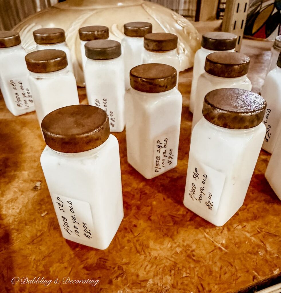 A set of 100 year old white spice bottles with caps at The Antique Warehouse Hudson NY