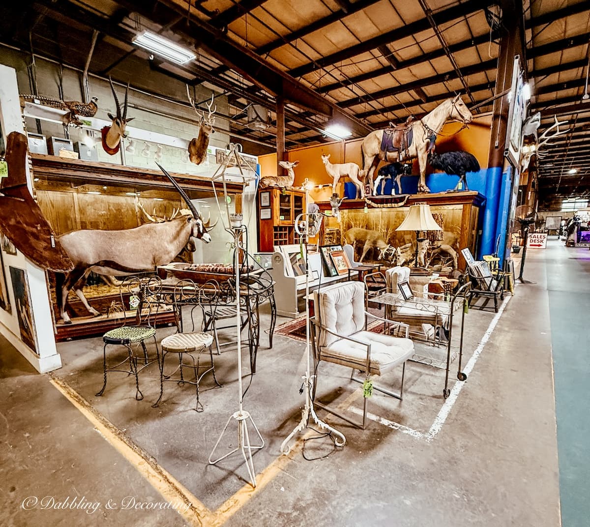 Eclectic vintage booth decor with taxidermy and mid century modern pieces inside The Antique Warehouse Hudson, NY.
