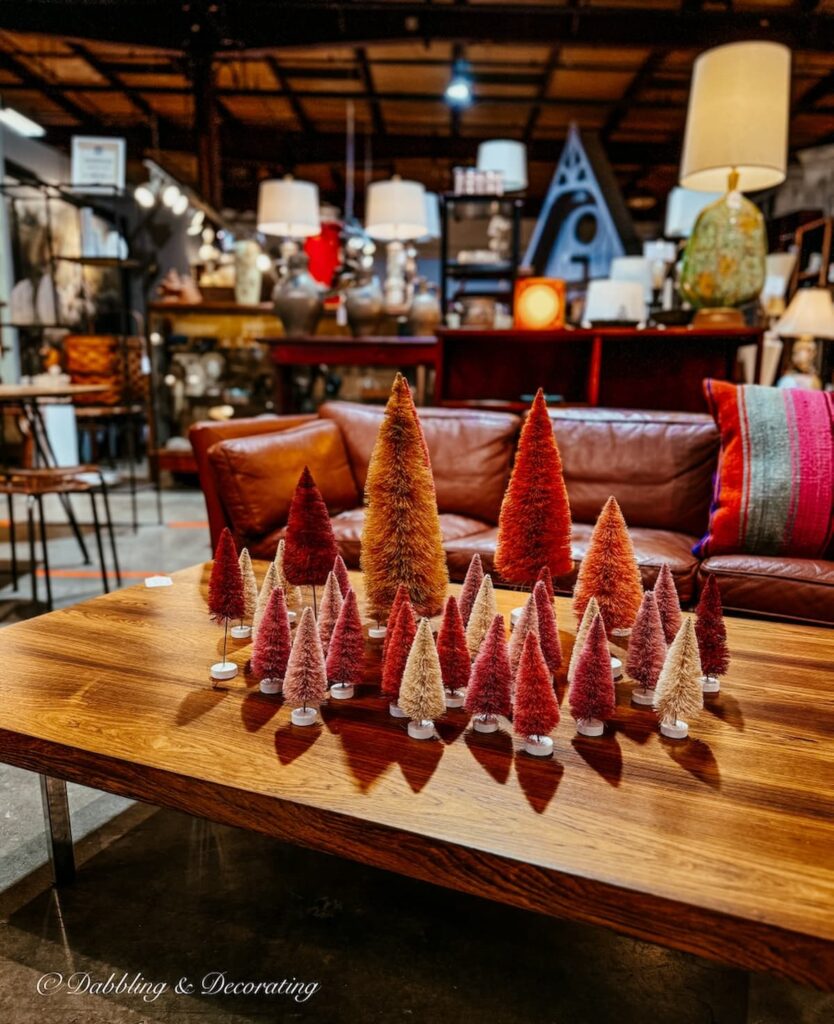 Collection of Pink and orange brush trees on mid century modern table inside The Antique Warehouse Hudson, NY.