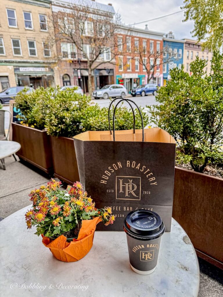 A bag of pastries and bake goods for breakfast with cup of coffee outside the Hudson Roastery on Warren Street in Hudson, NY.