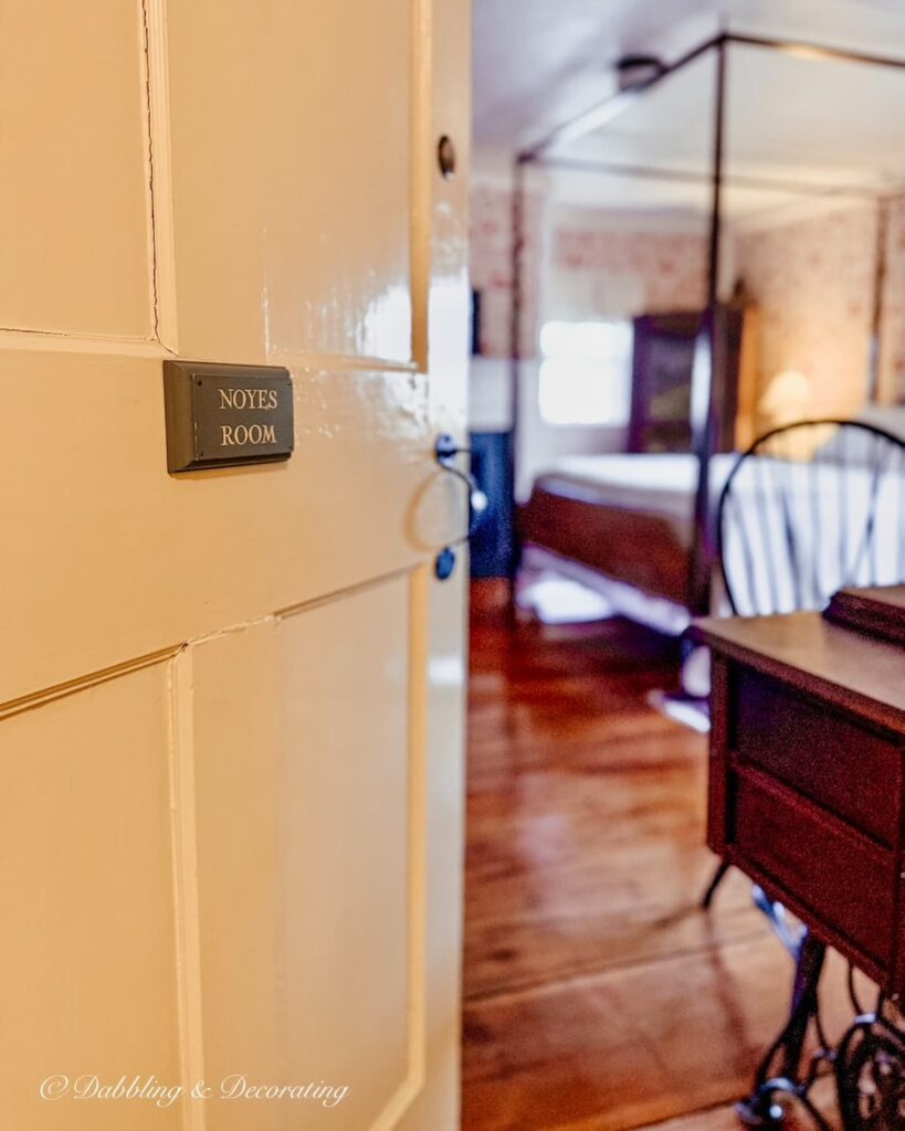The Clark Currier Inn room door open into the Noyes Room with canopy bed and colonial decor.