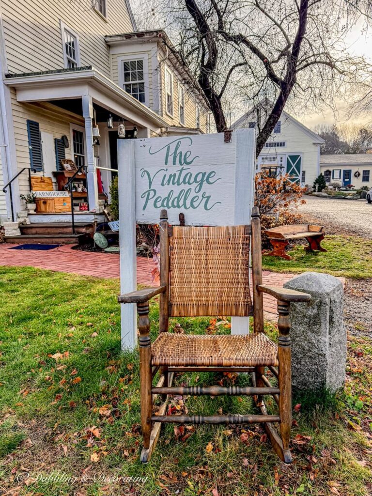 The Vintage Peddler sign with antique rocking and shop at the Todd Farm Antiques and Flea Market on a November morning.