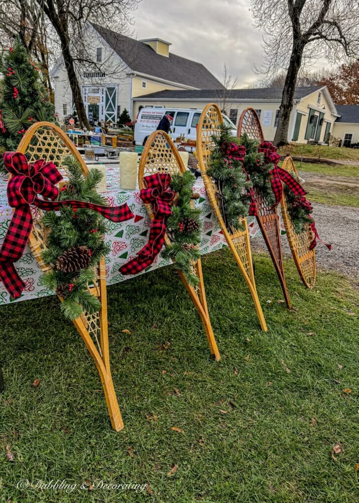 A row of four wooden vintage snowshoes with evergreens and bows at the Todd Farm Flea Market in Rowley, Massachusetts.