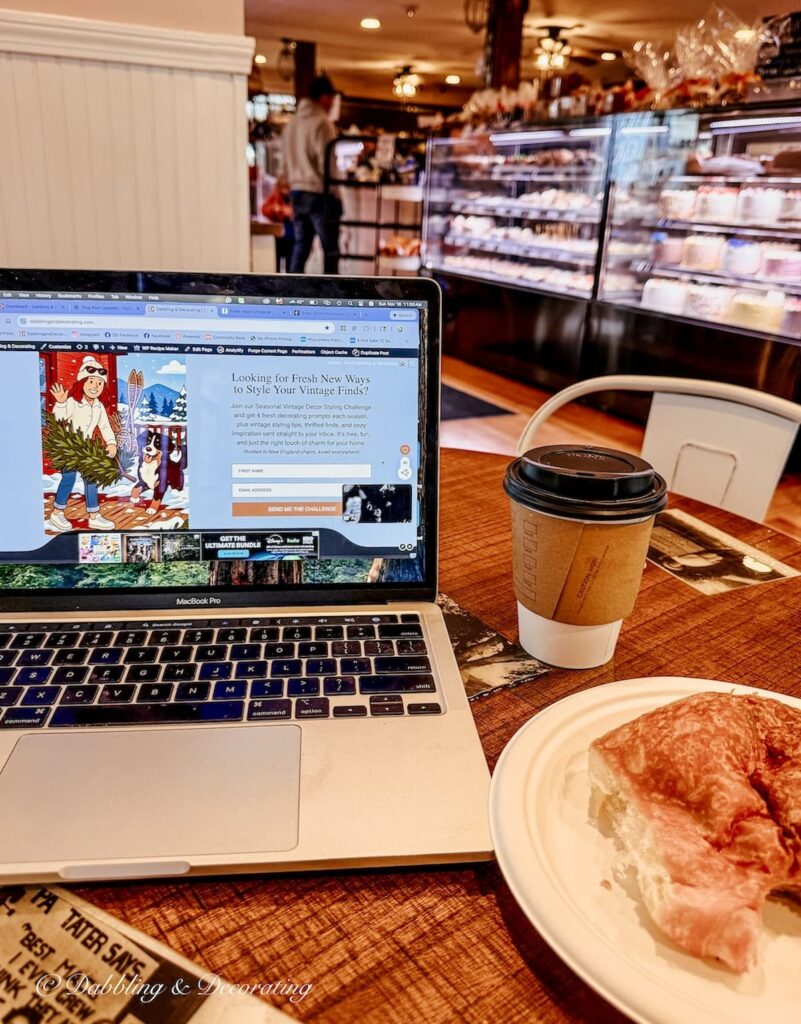 Laptop, coffee and chocolate croissant at table at the The Three Sweet Peas Bakery and Cafe in Rowley, Massachusetts.