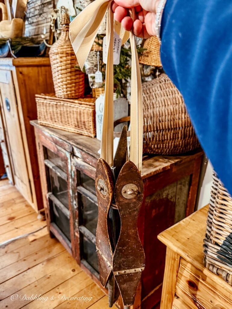 A pair of antique racing ice skates with ribbon in hand at The Barn at Todd Farm Antiques.