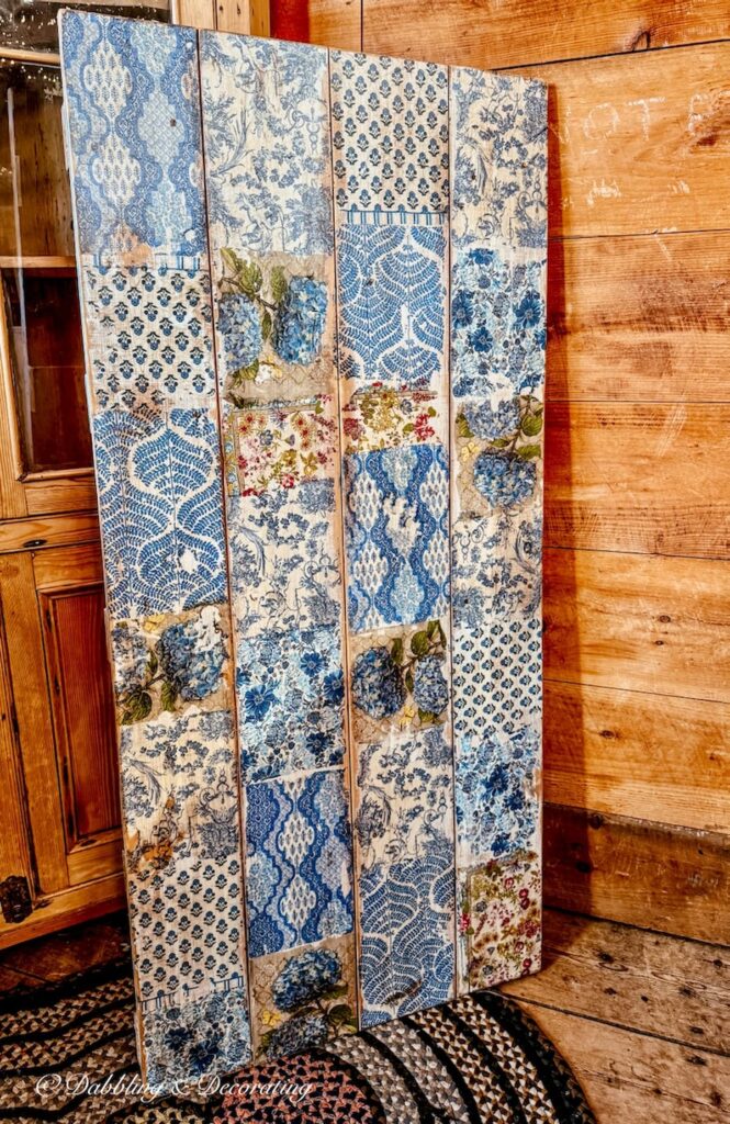 A handmade decoupaged door with blue patterns at The Barn at Todd Farm in Rowley, Massachusetts.