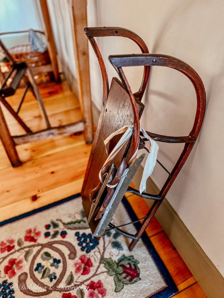Antique wooden sled with antique racing ice skates in vintage Christmas decorations in old colonial home.