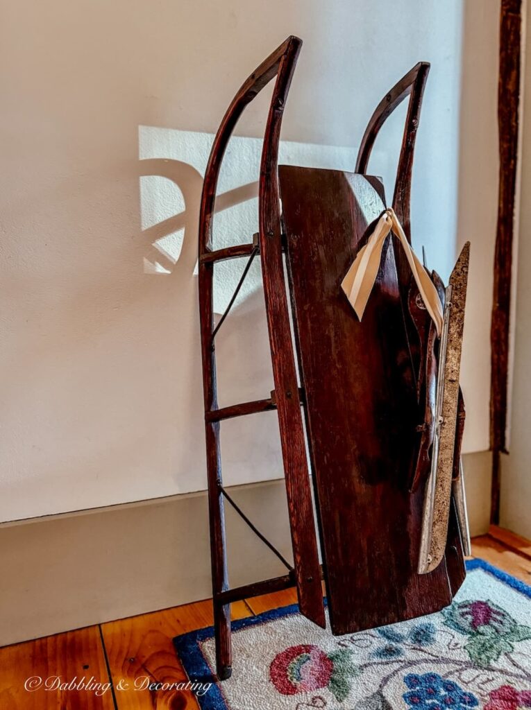 Antique wooden sled with antique racing ice skates displayed as vintage Christmas decorations ideas.