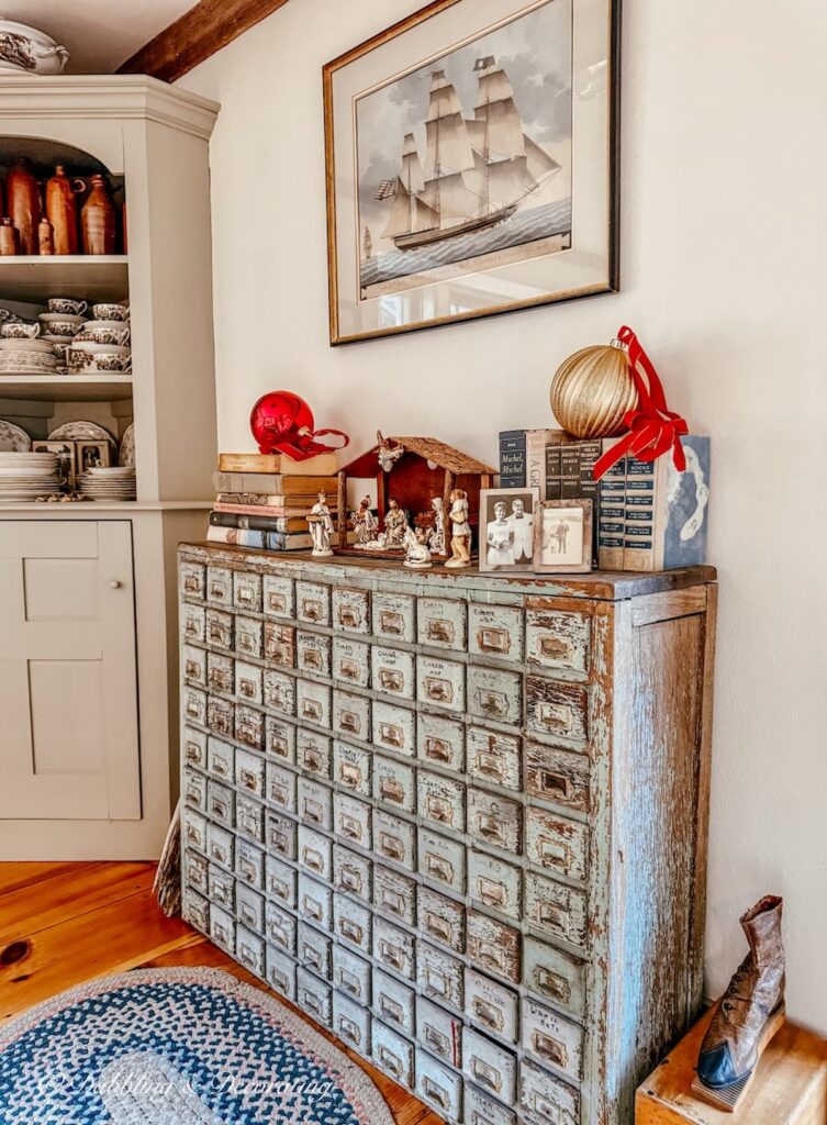 Antique apothecary with vintage Christmas decorations, Christmas manger, vintage books, and large Christmas ornaments.