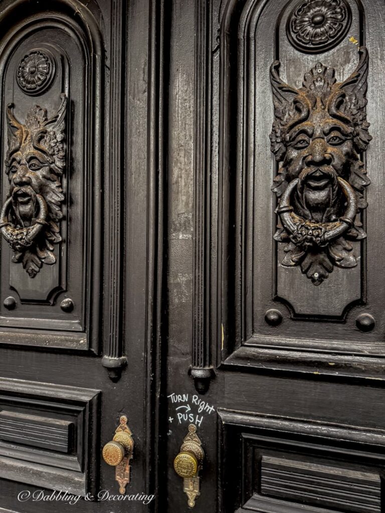 Two large spooky front doors in black entering into The Made INN Vermont in Burlington, VT.