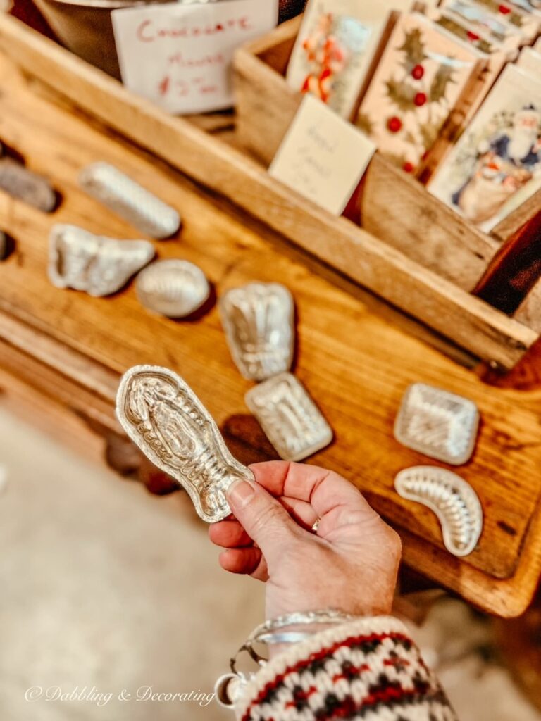 Small silver chocolate molds in hand at Barge Canal Market antiquing in Burlington, Vermont.