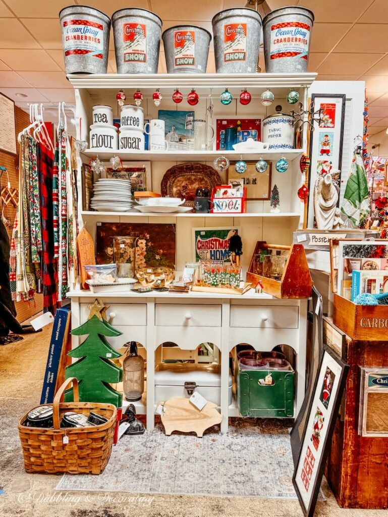 Vintage hutch with Vermont holiday items like old maple syrup buckets inside The Vintage Inspired Market antiquing in Burlington, Vermont.