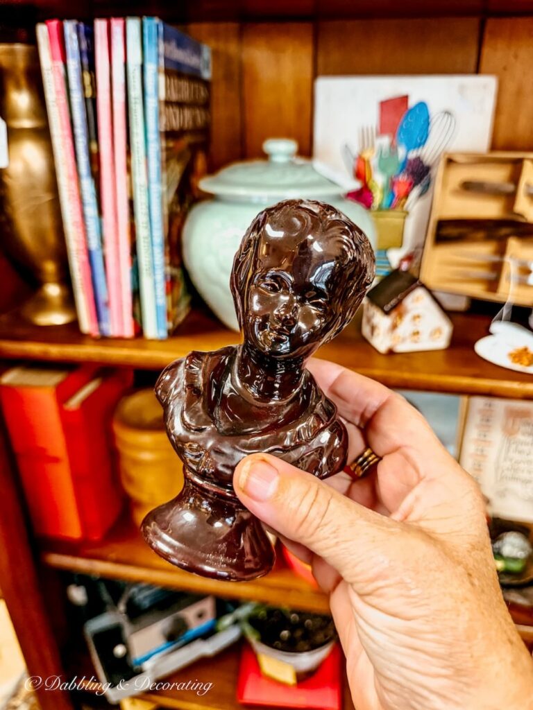 Small brown porcelain bust in hand at The vintage Inspired market antiquing in Burlington, Vermont.