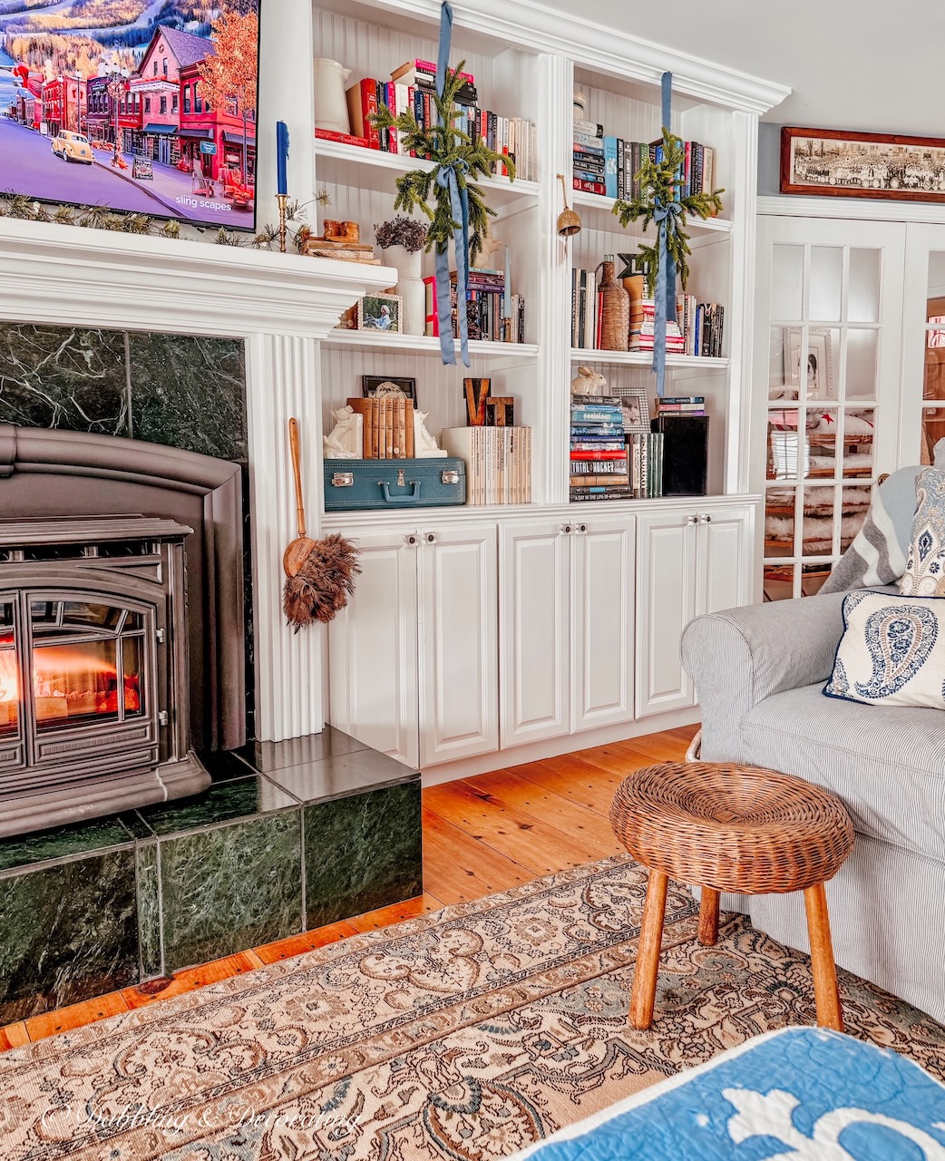 Cozy living room with eclectic Christmas bookshelf decor in built-in bookshelves with fireplace.