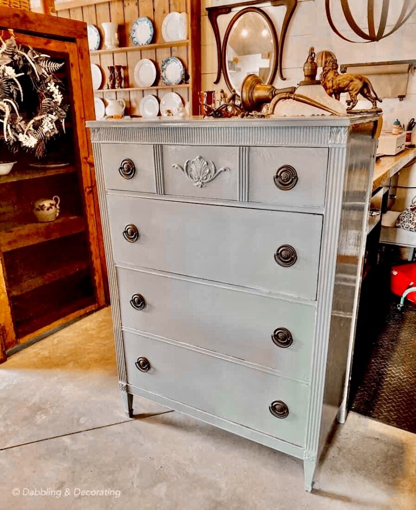 Vintage dresser decorating ideas with an old blue gray painted dresser with antique hardware in antique store.