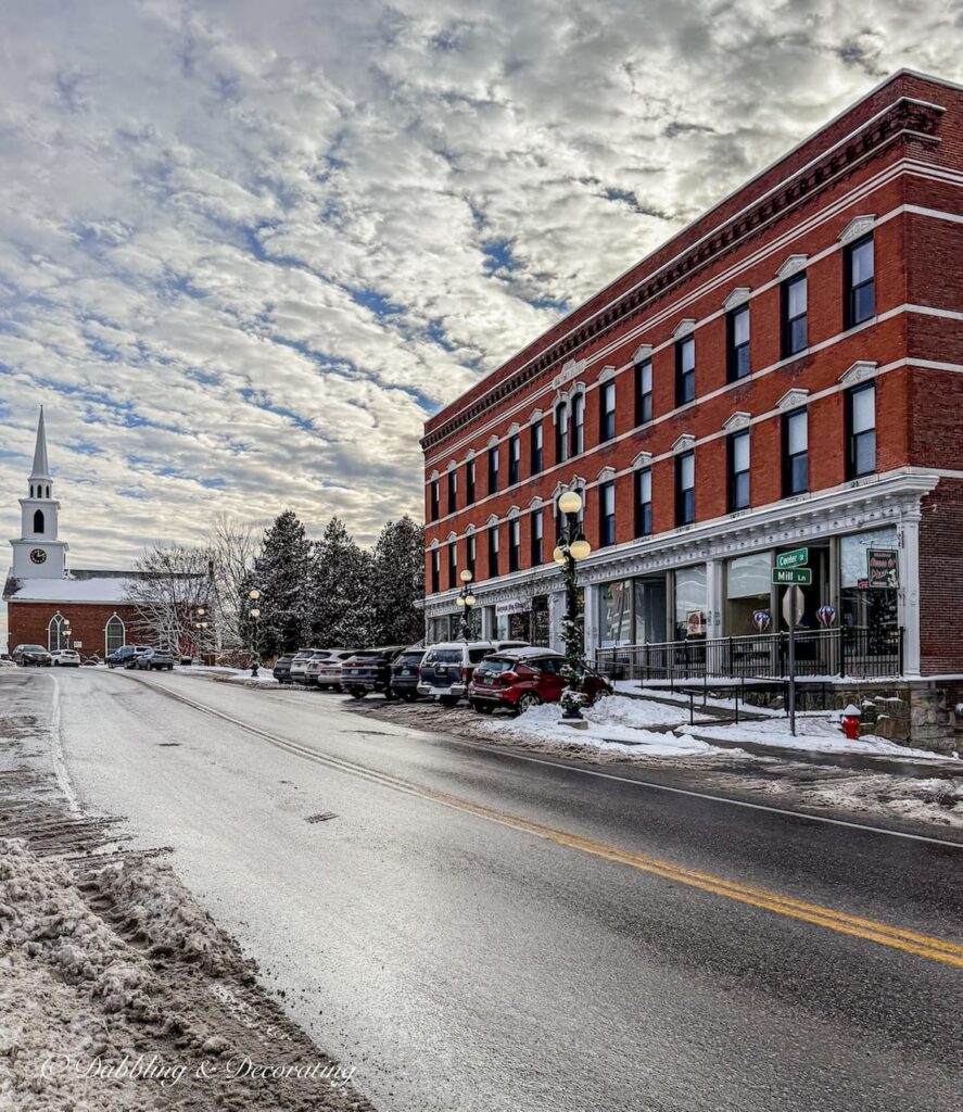 Street view looking for antique shops of Brandon, Vermont with Church in the snow.