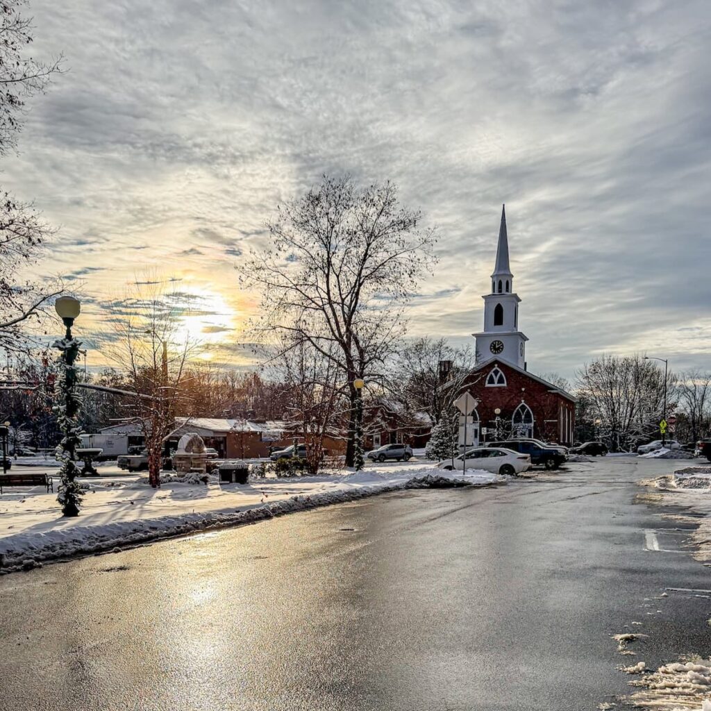 A snowy street and church scene looking for antique shops in Brandon, Vermont.