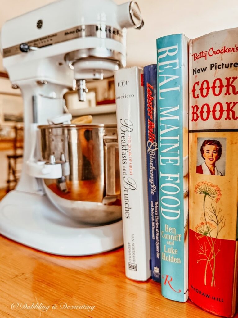 Vintage cookbooks next to a thrifted KitchenAid mixer in kitchen winter home decor ideas.