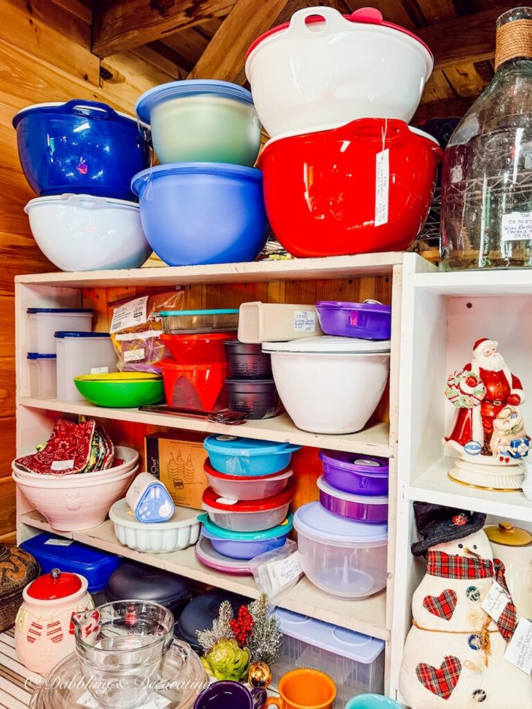 Colorful large kitchen bowls and Tupperware display at The Willows Flea Market in Maine.