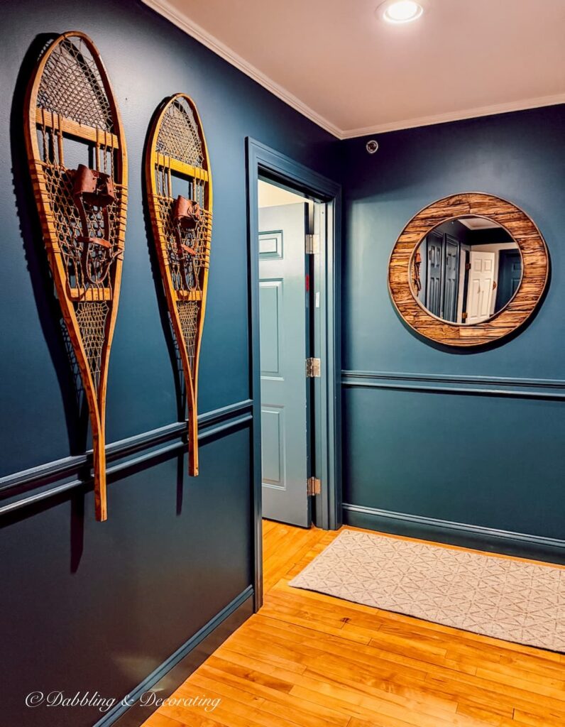 Blue hallway with vintage snowshoes hanging on the wall at the Wolf Cove Inn in Poland, Maine on Tripp Lake.