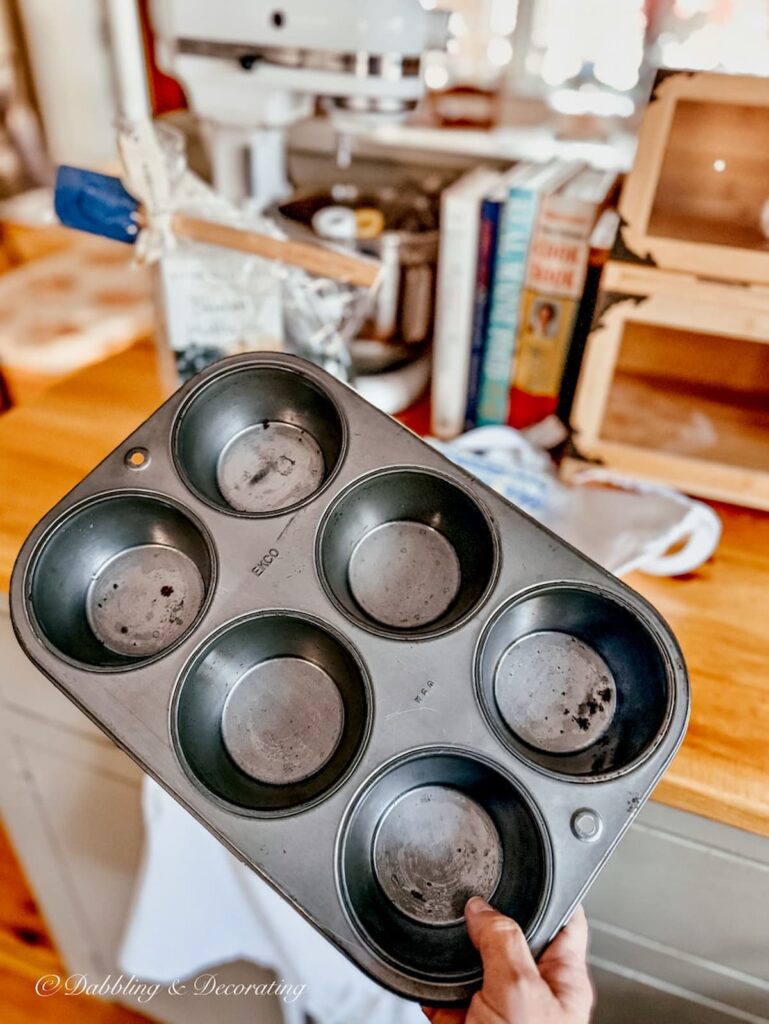Vintage thrifted cupcake tin in hand in the kitchen.