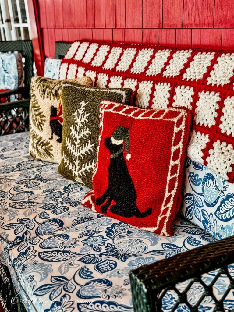 Three Chandler 4 Corners pillows on outdoor porch with thrifted red and white afghan.