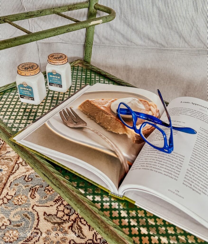 Tea cart styling ideas with open cookbook and vintage spice jars.