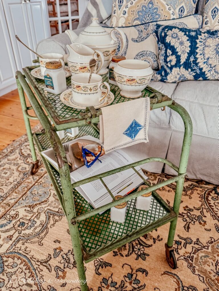 Tea cart styling ideas with an antique bar cart, Aynsley's Banquet tea set and vintage tea towels in living room.