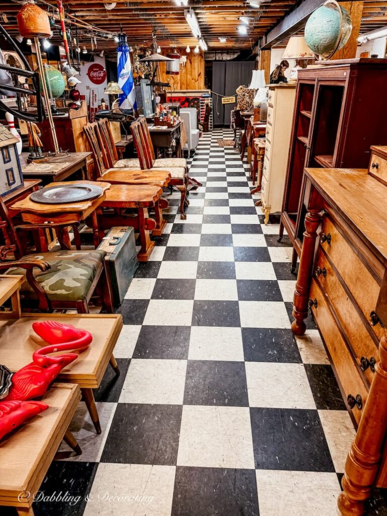 Basement floor at Vermont Antique Mall with black and white checkered floors filled with antique furnishings.