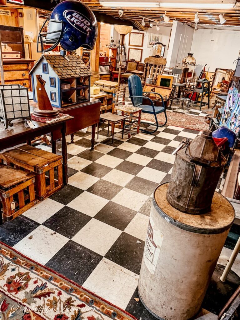 Basement floor at Vermont Antique Mall with black and white checkered floors filled with antique furnishings.