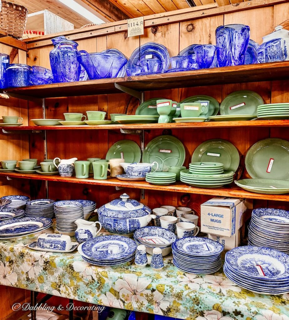 Vintage Vendor booth with shelves filled with blue and white vintage willow dishes and Jadeite along with blue glassware dishes at Vermont Antique Mall.