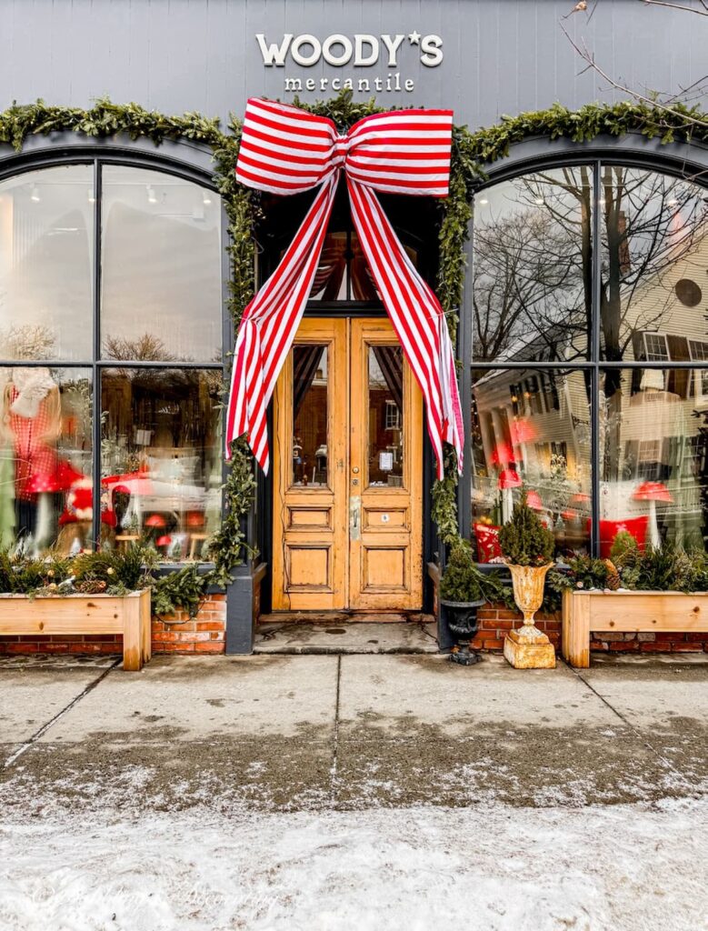 Woody's Mercantile storefront with large red and white bow decorated for Christmas in downtown Woodstock, Vermont.