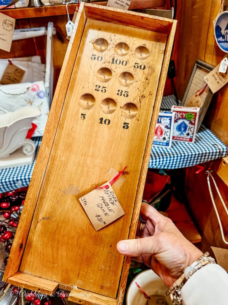 Antique marble board game in hand at antique store for apres ski decor ideas.
