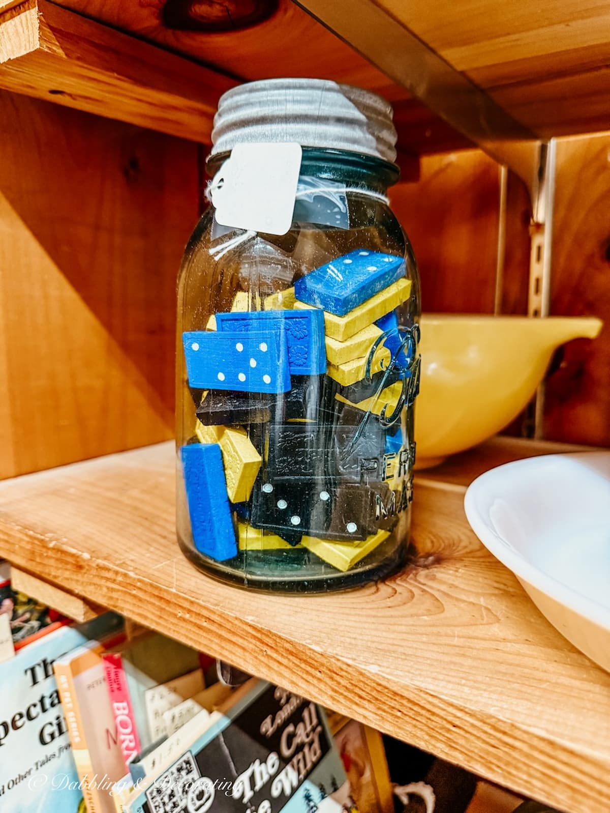 Mason jar filled with dominoes on antique store shelf for apres ski decor ideas.