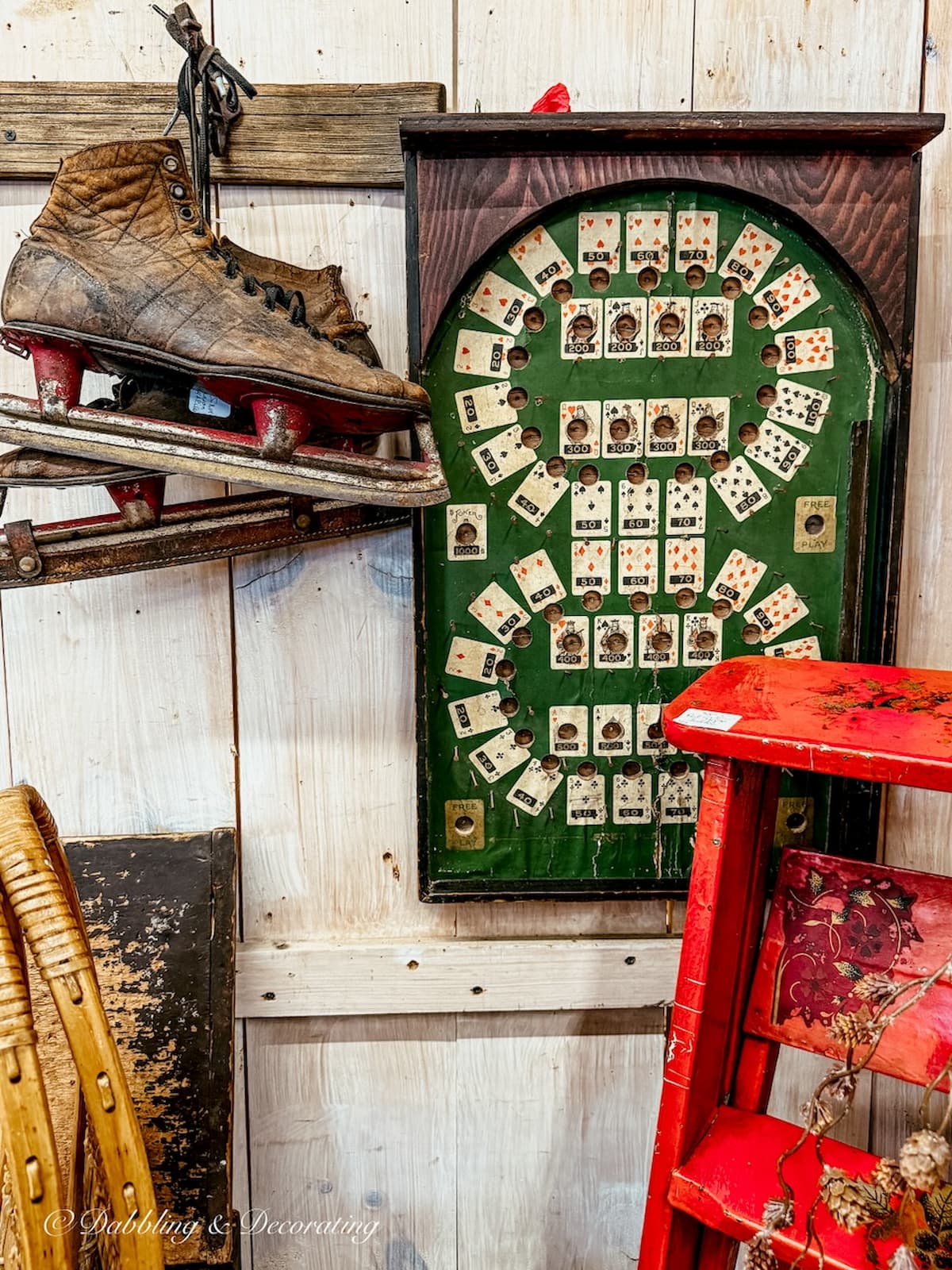 Antique booth with hockey skates, red ladder and antique game board hanging on the wall for apres ski decor ideas.