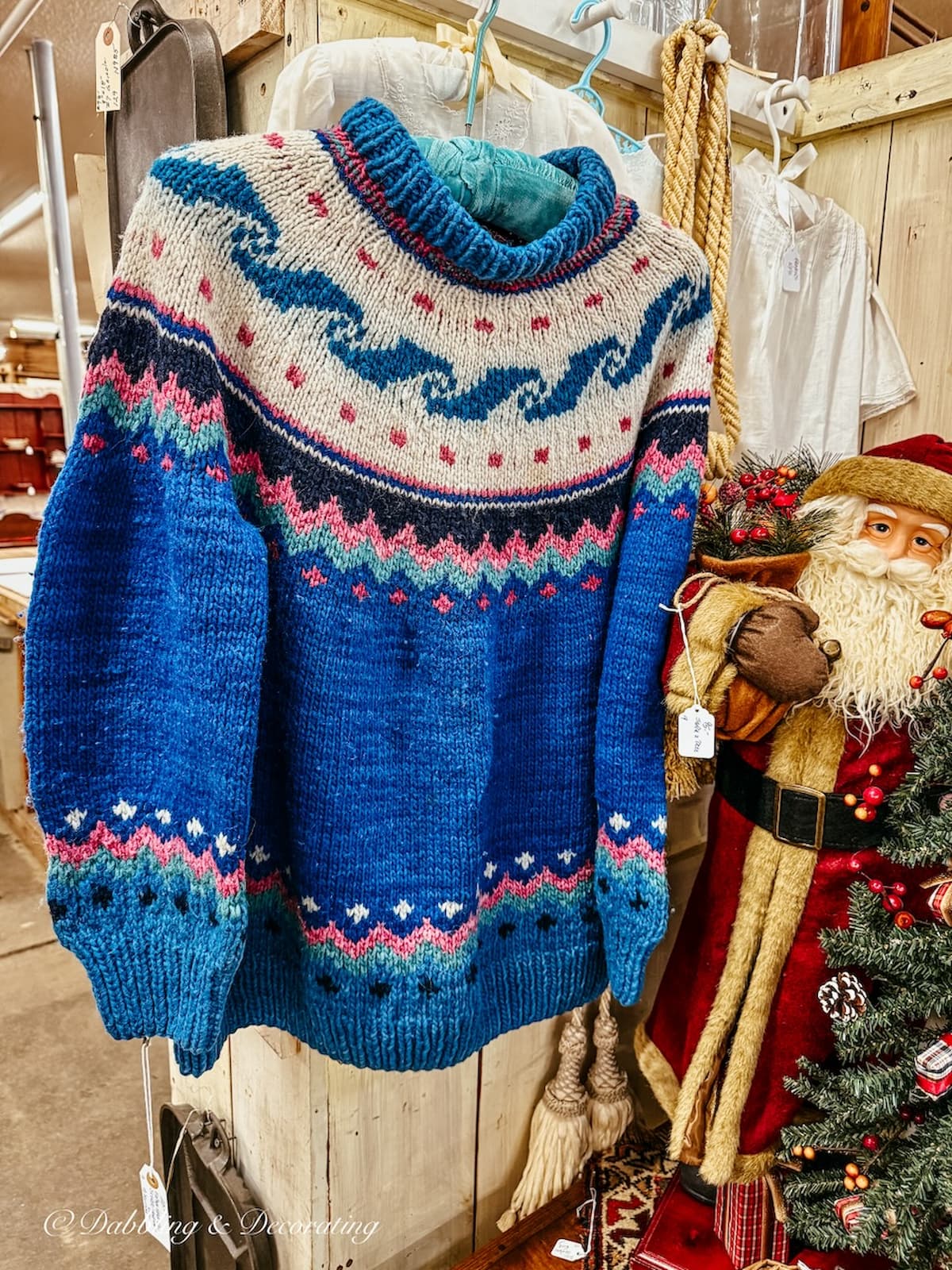 Vintage blue ski sweater hanging up in antique store for apres ski decor ideas.