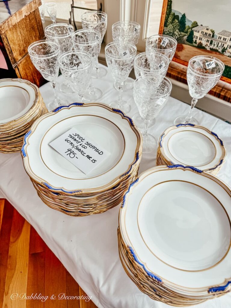 A set of Spode Sheffield Tiffany & Co. 60 piece set marked $995 along with crystal wine glasses priced at $35 each in how to shop estate sales at a luxury estate sale in Vermont.