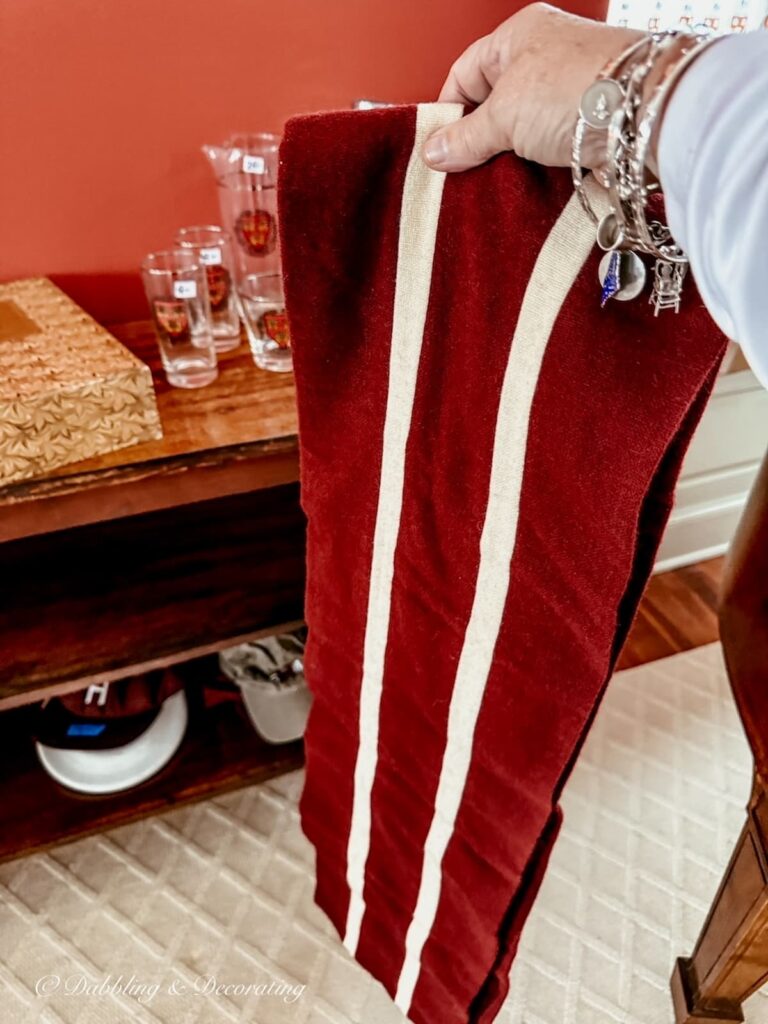 A Harvard University scarf in red and white striped in hand on how to shop estate sales at luxury homes.
