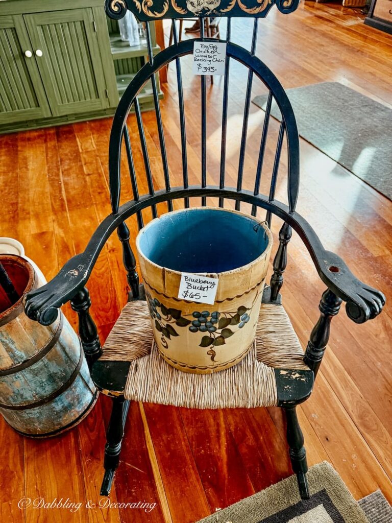 Antique chair with antique blueberry bucket on it at an estate sale in Vermont at a high end luxury home.