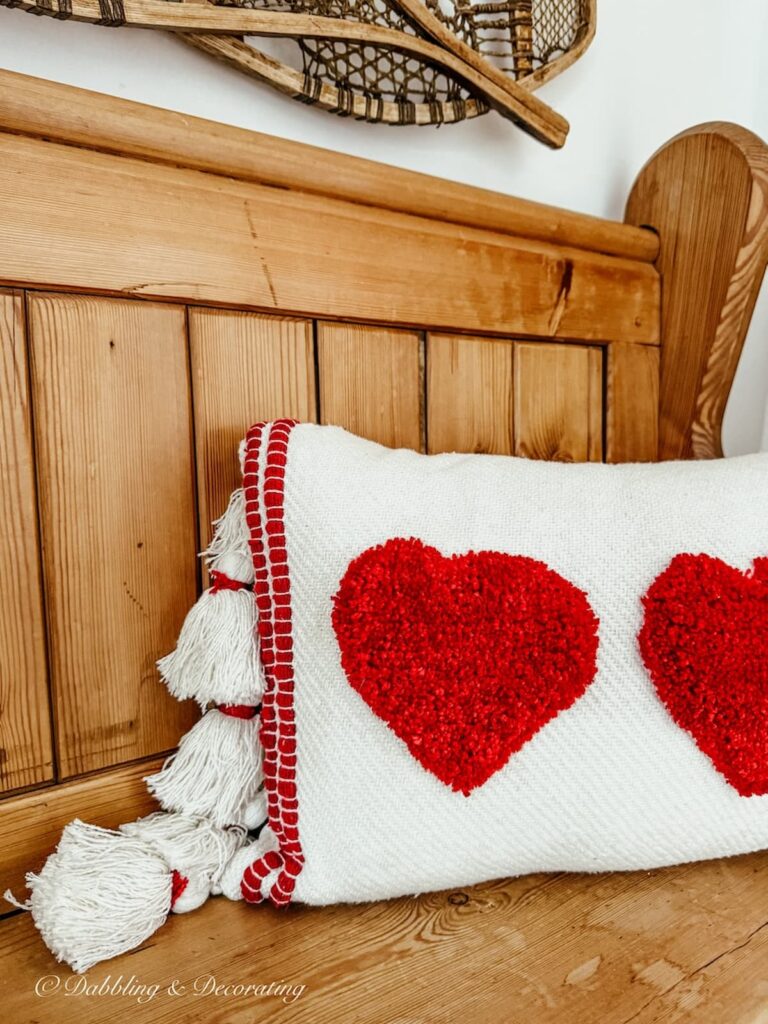 Church pew bench entryway with Valentine's Day pillow with red hearts from Antique store.