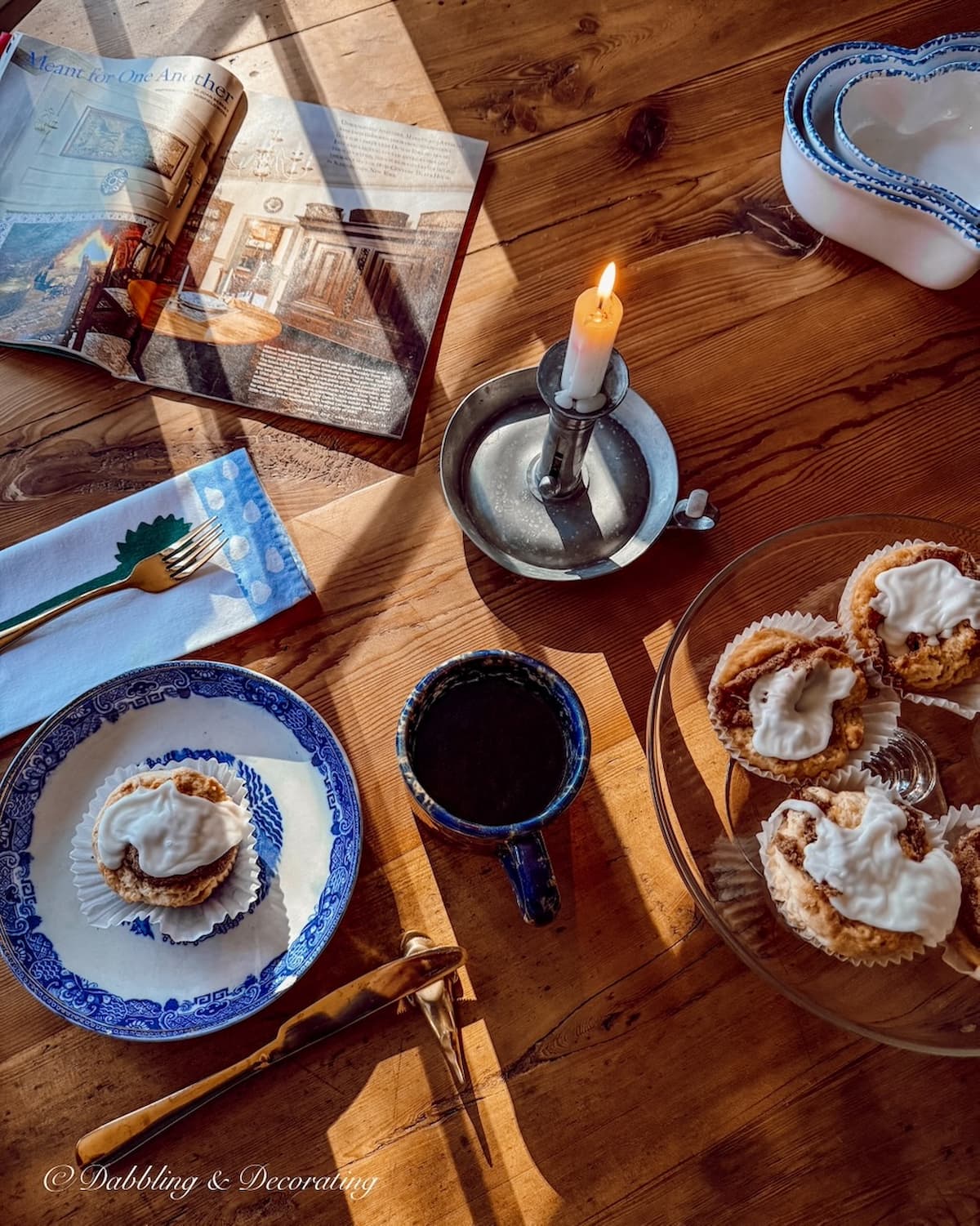Moody dining room table with antique blue and white place setting with candle light and cinnamon buns for Sunday home vibe; decorating with antiques.