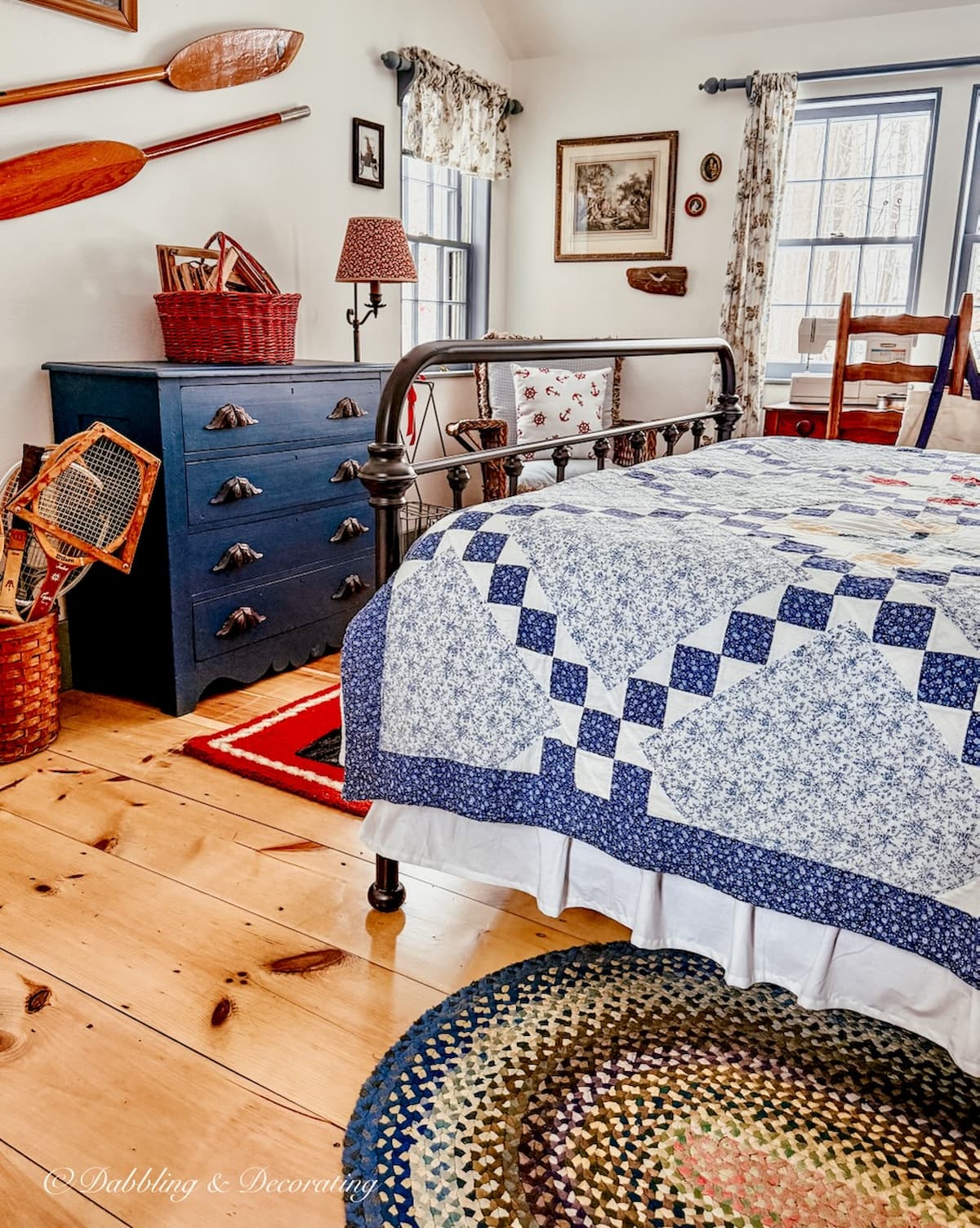 Red, white, and blue coastal vintage styled guest bedroom with quilt, navy blue dresser, wall oars, handmade braided rugs and more for a Sunday Home Vibe.