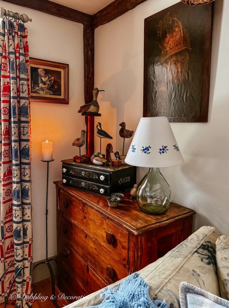 Antique styled living room corner with antique wooden dresser, driftwood bird collection and coastal drapes for a Sunday home vibe.