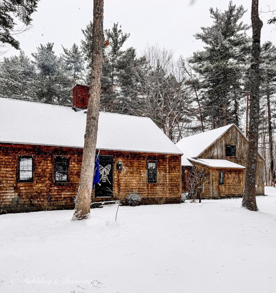 Cedar Shakes home in the snow in Maine with snowshoes on the front door.