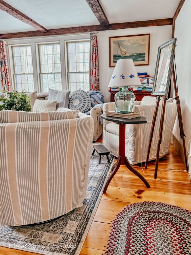 Coastal antique styled living room with braided rugs two swivel sleep covered chairs with a Sunday home vibe.