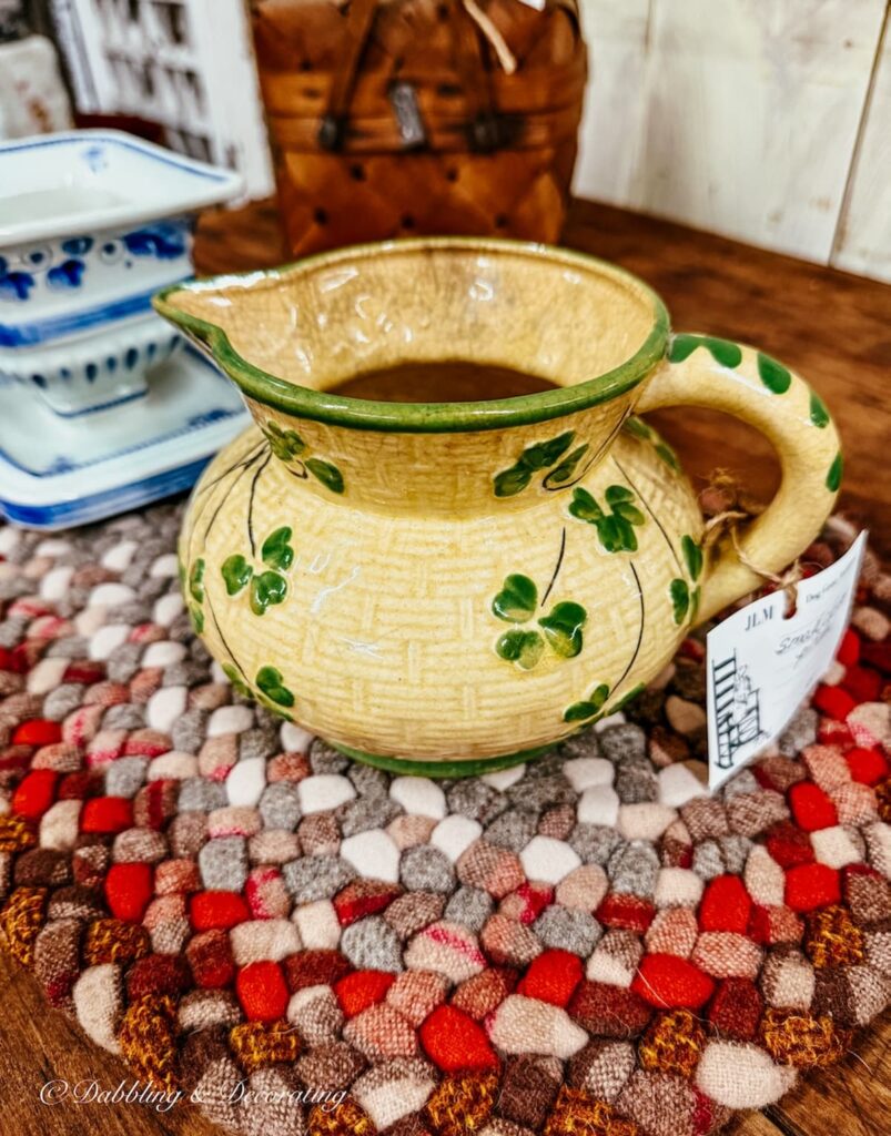 Antique yellow small pitcher with green shamrocks in antique store for St. Patrick's Day Decor ideas.