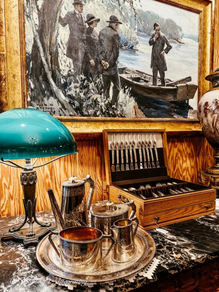 Silver tea set on serving tray side by side with a silver cutlery set inside Waverly Square Antiques antiquing in Saratoga Springs.