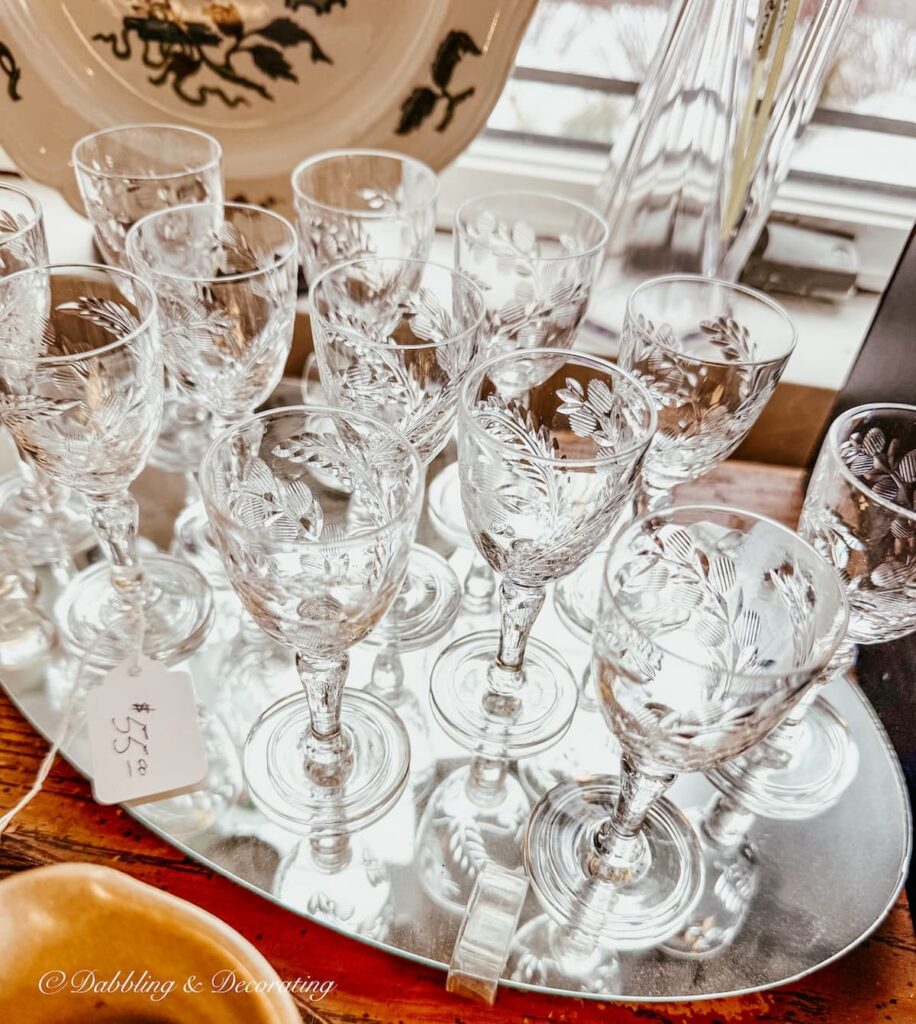 Silver tray with a large set of Crystal glasswares that would have been used in a Parlor in the Gilded age on display in antique store in Saratoga.
